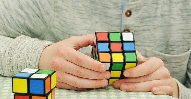 a male solving a Rubix cube